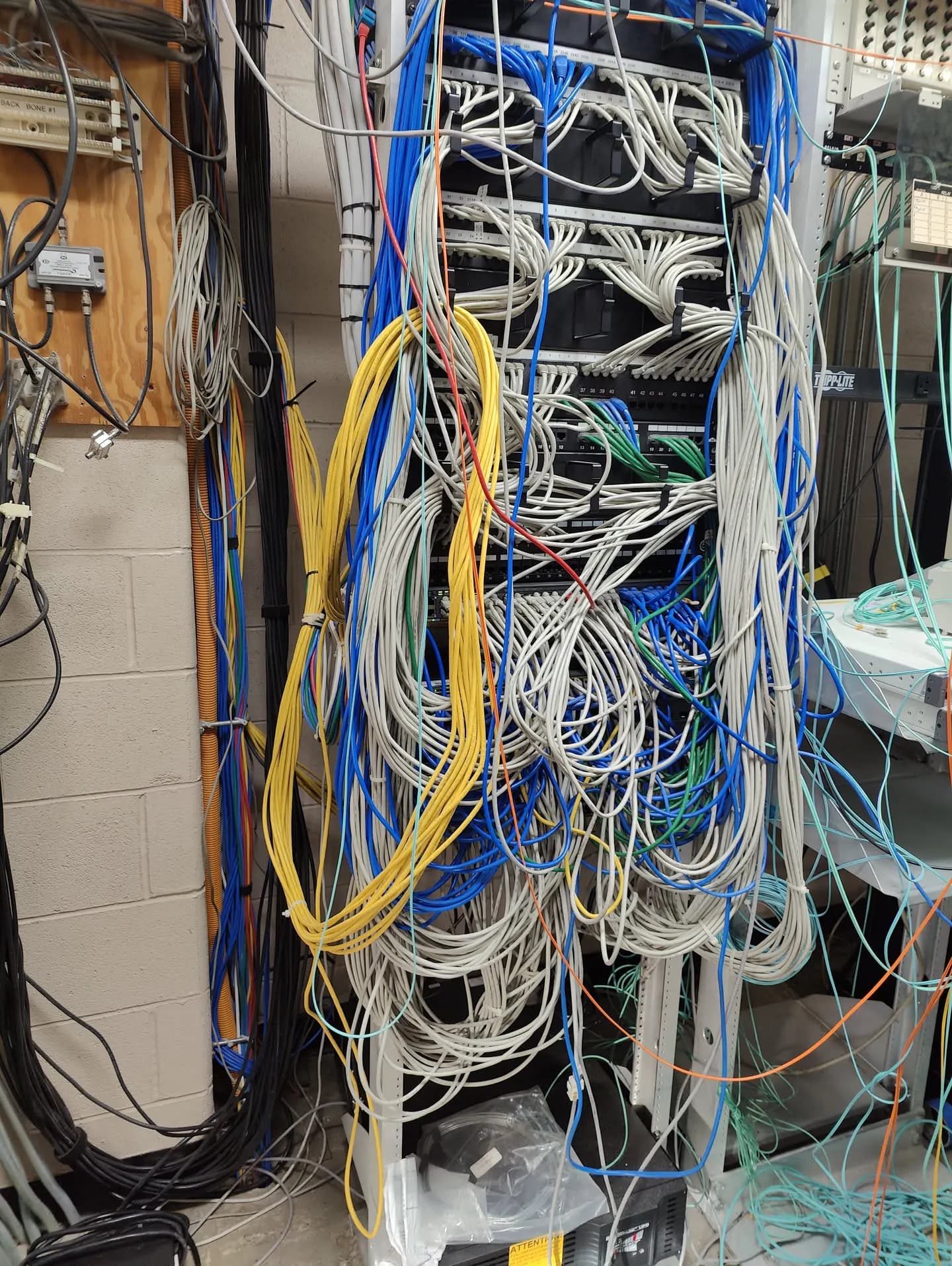 Network closet, before. A tangle of unlabeled drops and leftover cable
